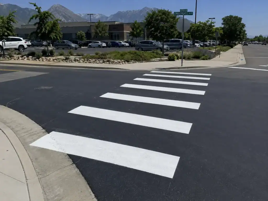 Fresh crosswalk striping on asphalt at a commercial property in Salt Lake City, Utah.