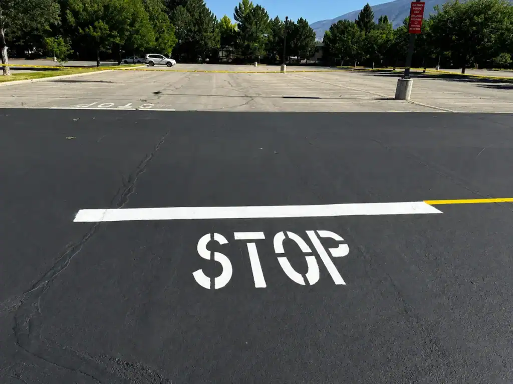 Fresh STOP pavement marking painted on a commercial parking lot in Salt Lake City, Utah.