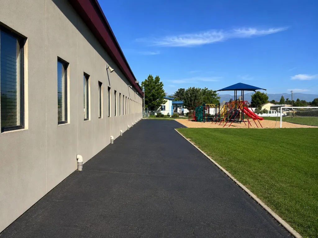After photo of freshly sealcoated playground asphalt at Timpanogos Academy in Lindon, Utah with restored pavement.