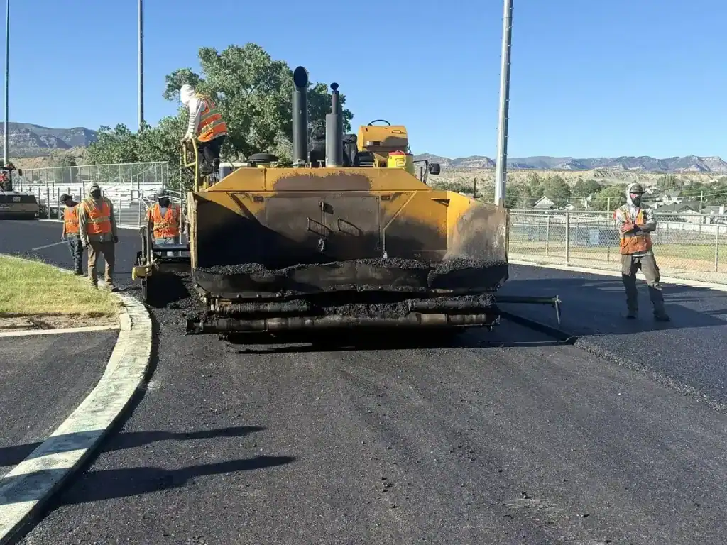 Eckles Paving crew operating an asphalt paver on the Carbon High School track in Price, Utah.
