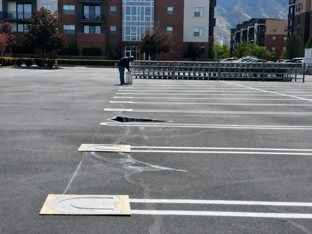 Rounded parking-stall edges being painted with stencils at the Costco parking lot in Orem, Utah.