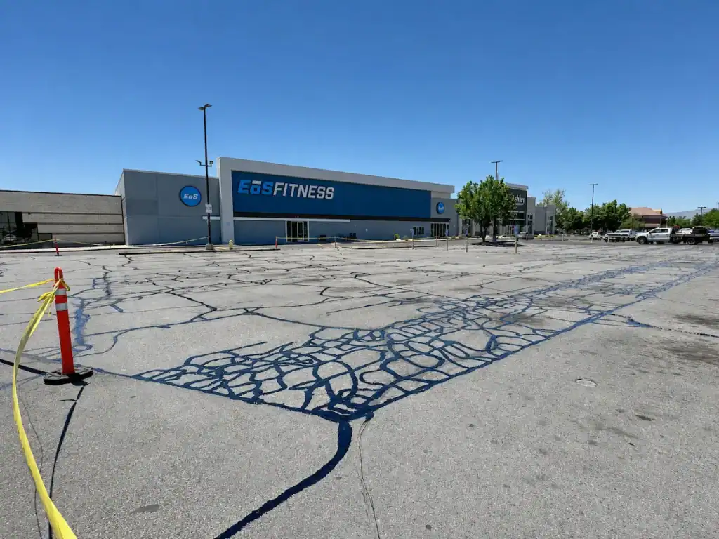 Crack-sealed asphalt parking lot at EOS Fitness in Orem, Utah, following preventive pavement maintenance.
