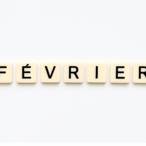 Mot « fevrier » formé avec des lettres de type Scrabble beiges sur fond blanc minimaliste, représentant le mois de mai pour un article voyage « Où aller en Europe en fevrier ».