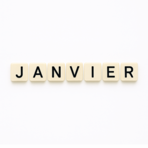 Mot « janvier » formé avec des lettres de type Scrabble beiges sur fond blanc minimaliste, représentant le mois de mai pour un article voyage « Où aller en Europe en janvier ».