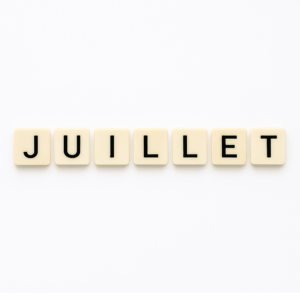 Mot « juillet » formé avec des lettres de type Scrabble beiges sur fond blanc minimaliste, représentant le mois de mai pour un article voyage « Où aller en Europe en juillet ».