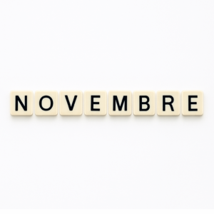 Mot « novembre » formé avec des lettres de type Scrabble beiges sur fond blanc minimaliste, représentant le mois de mai pour un article voyage « Où aller en Europe en novembre ».