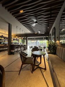Interior restoran modern di Canggu dengan pencahayaan hangat dan dekorasi alami.