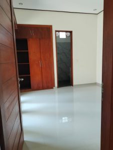 Ruang dalam villa 2 kamar tidur dengan interior minimalis dan pintu kayu.