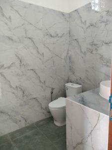 Kamar mandi modern dengan toilet dan wastafel di villa dekat destinasi wisata.