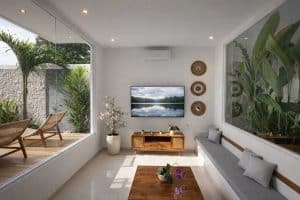 Villa tropis modern di Nusa Dua dengan ruang tamu cerah dan pemandangan taman serta sunset yang mena.