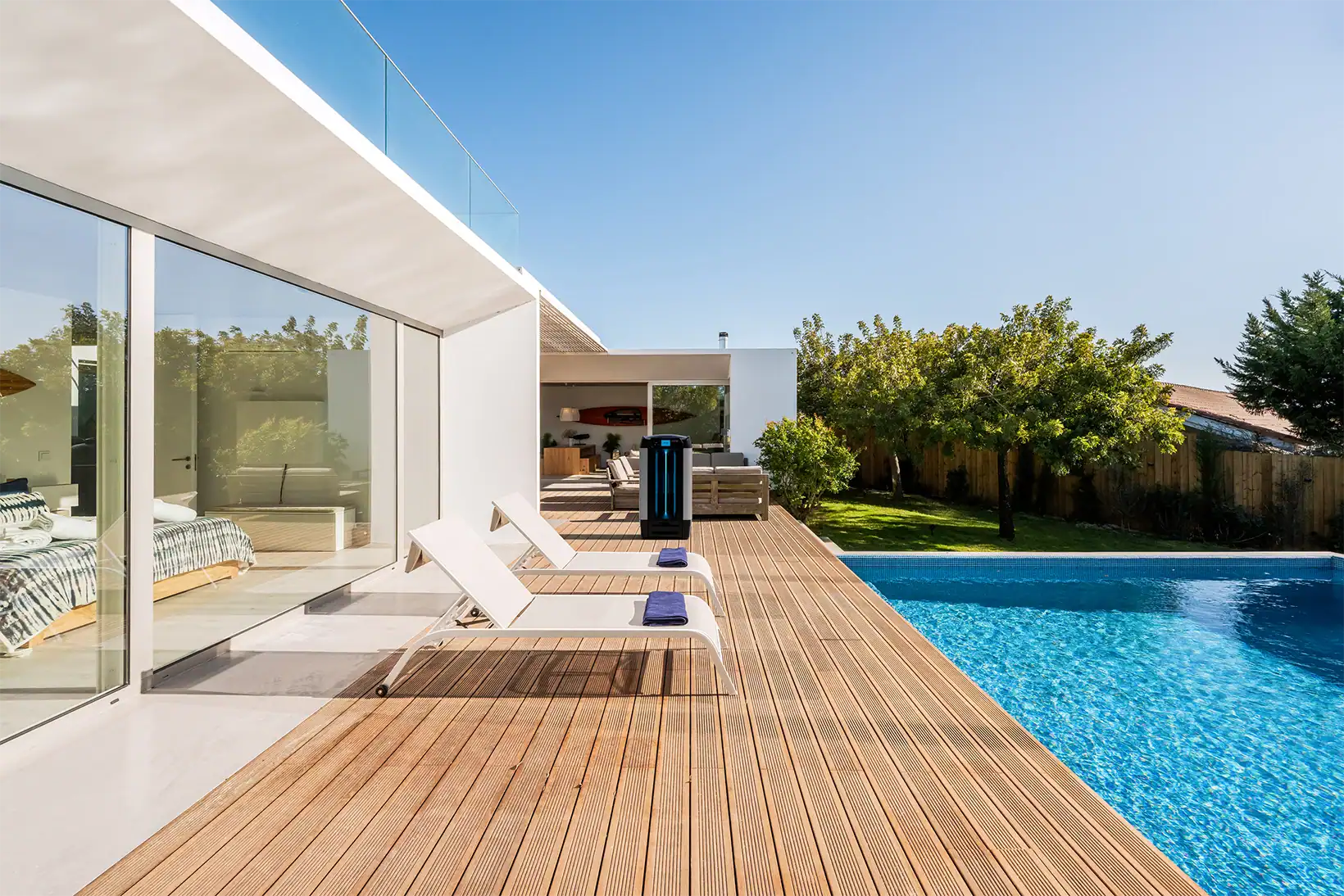 Aero evaporative cooler positioned on a modern poolside deck at a contemporary home, complementing the outdoor lounge area.