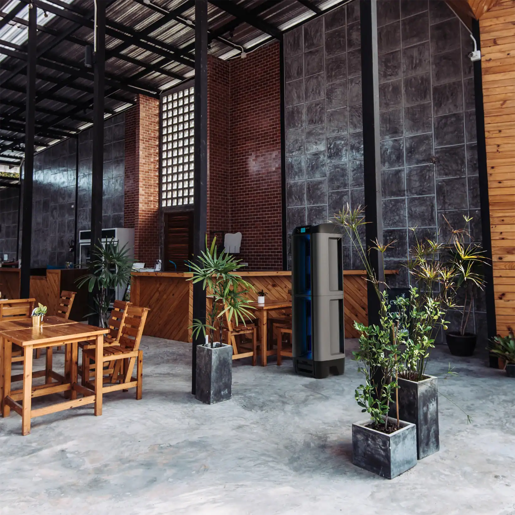 Aero evaporative cooler placed in a modern open-air café with wood and concrete design elements
