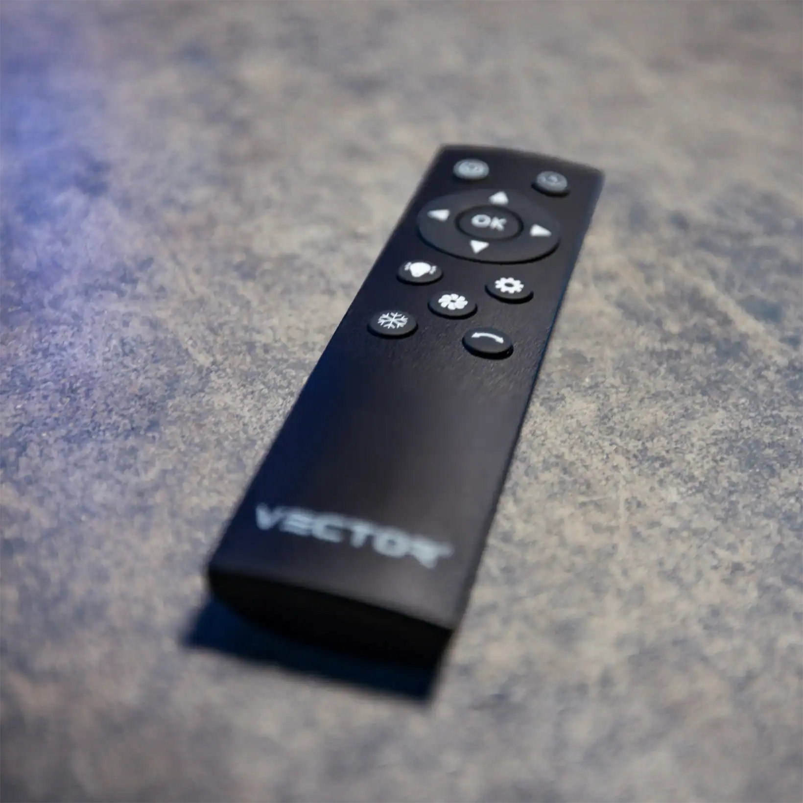 A Vector remote control placed on a wooden table.