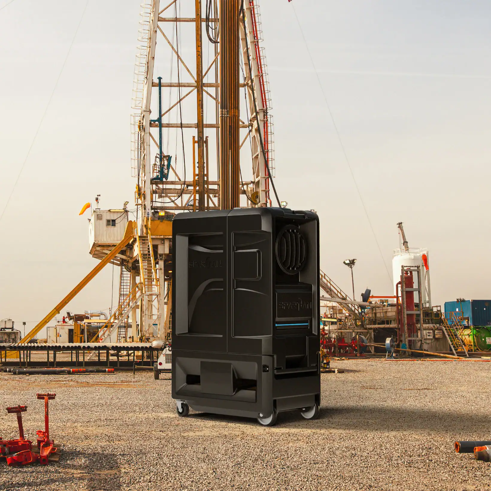 Spartan evaporative cooler positioned on an industrial job site near oil rigs, demonstrating its rugged, field-ready design for demanding environments.