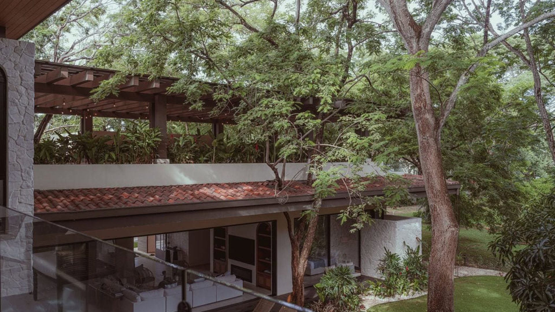 Lush backyard with mature trees and outdoor living space, perfect for relaxing and enjoying nature.
