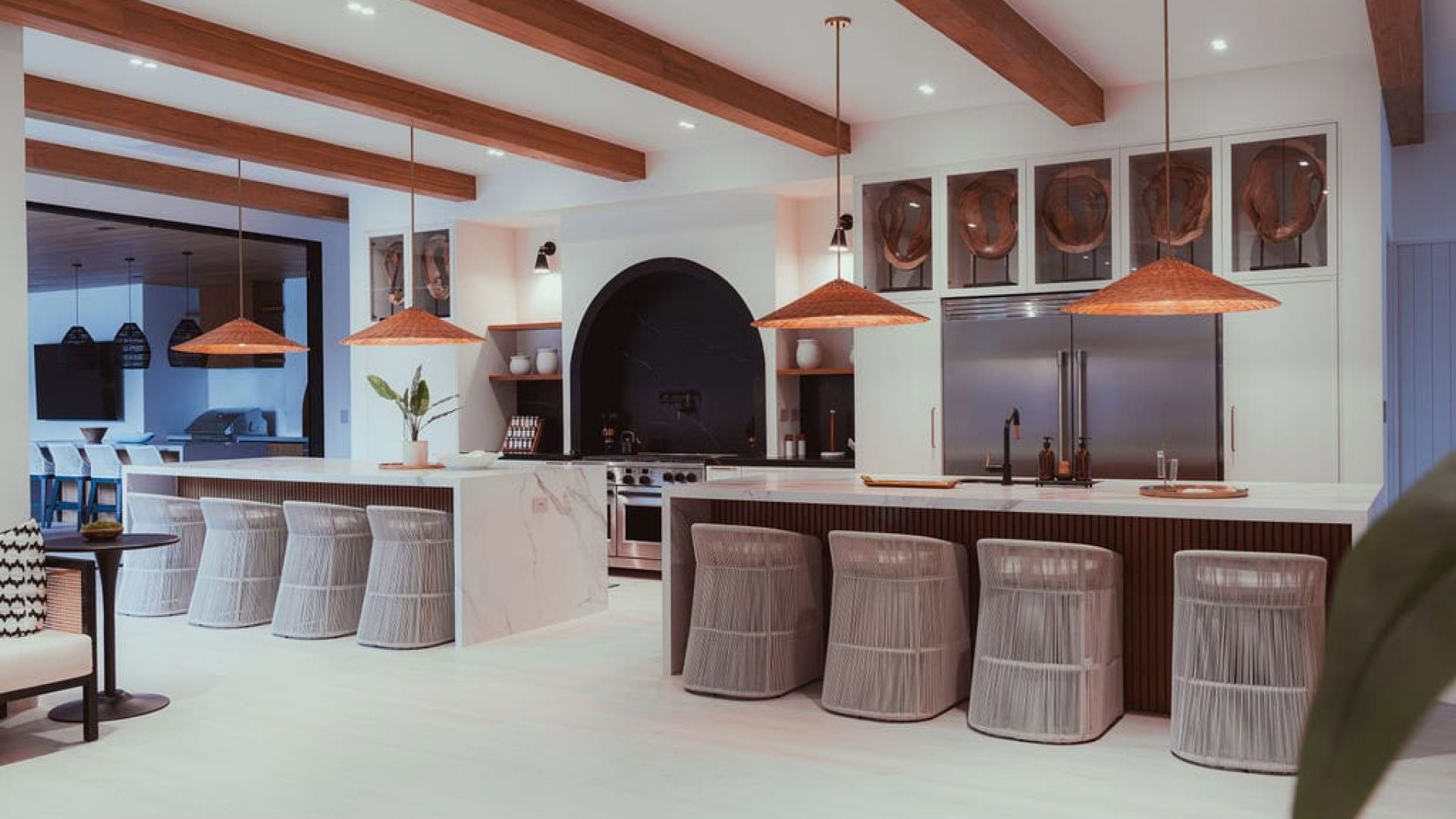 Modern bright kitchen with white cabinets and wood accents, featuring a large island and stylish pendant lighting.
