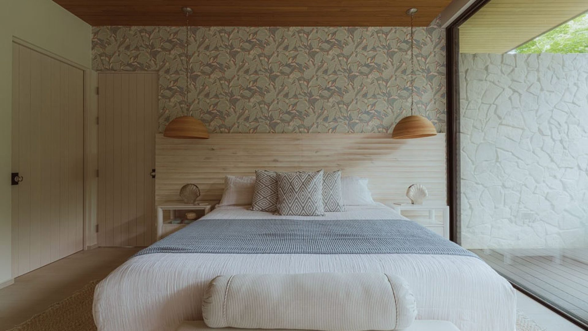 Serene bedroom with modern decor, natural wood accents, and scenic view, perfect for relaxing and rest.