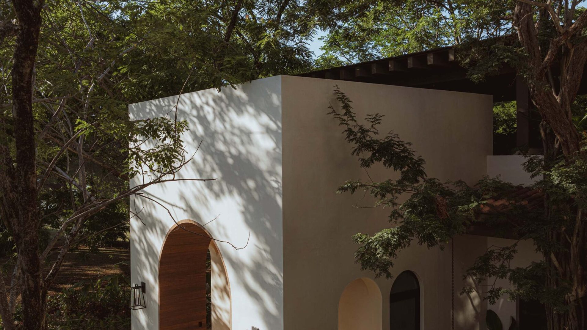 Modern minimalist house surrounded by greenery in a lush garden, contemporary architecture, Vida Pinilla design, eco-friendly home.