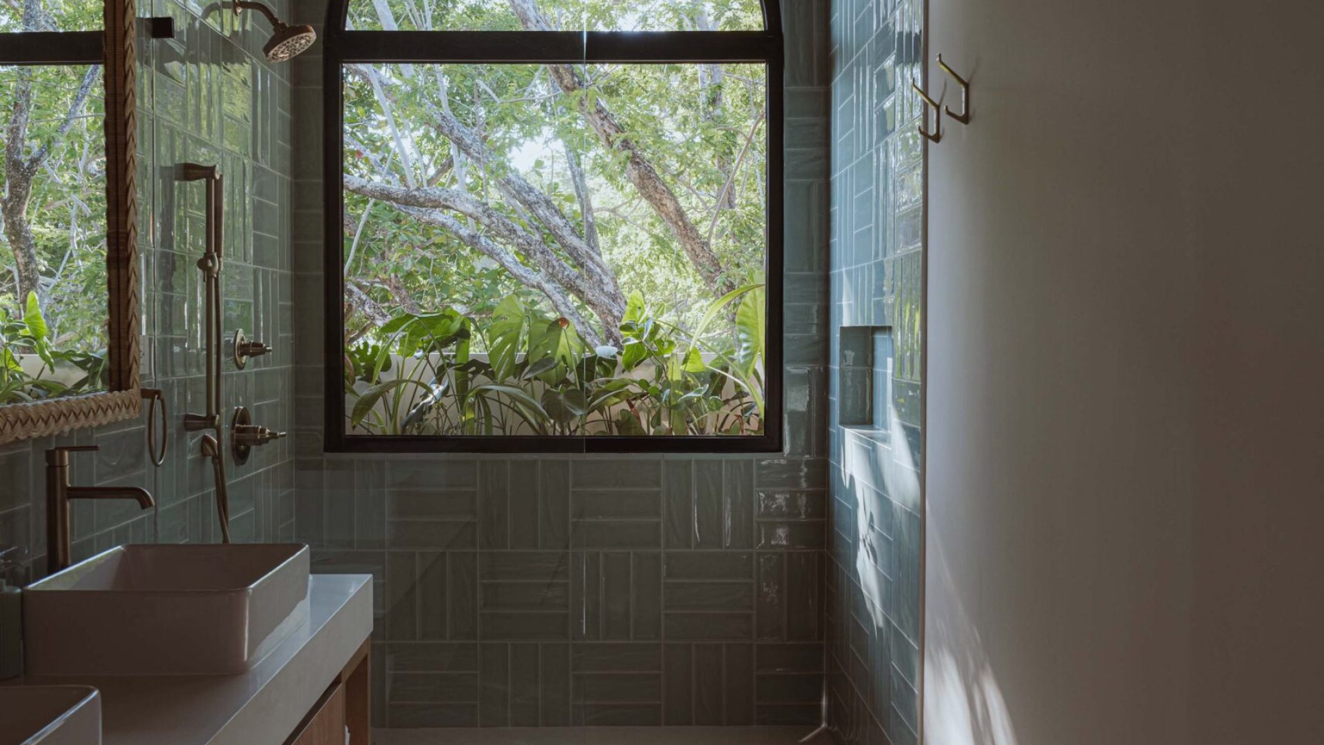 Bright modern bathroom with large arched window overlooking lush greenery, natural light, minimalist design, and eco-friendly decor.