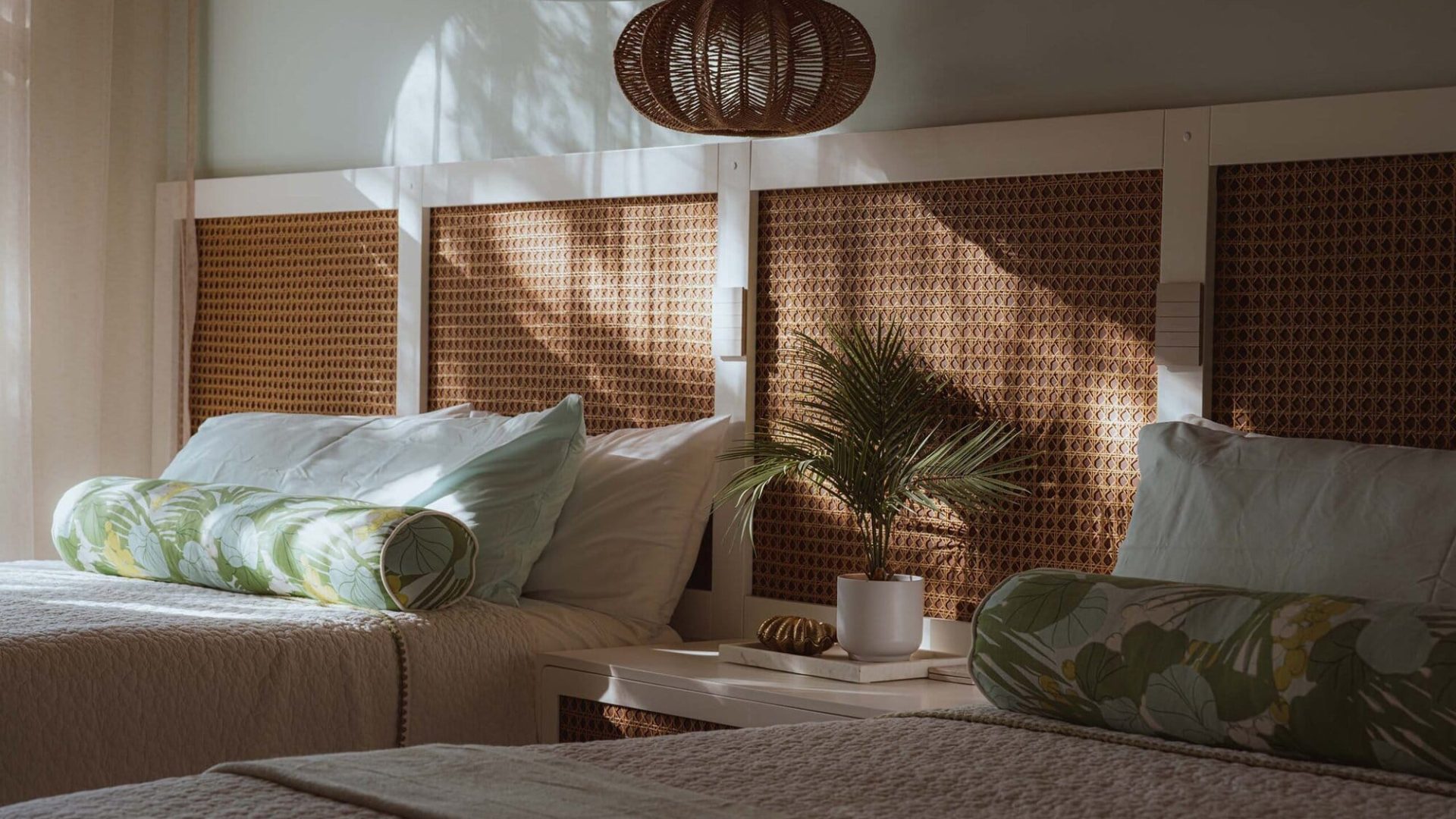 Glass and wood bedroom decor with rattan headboard and tropical accents, cozy and elegant bedroom design.