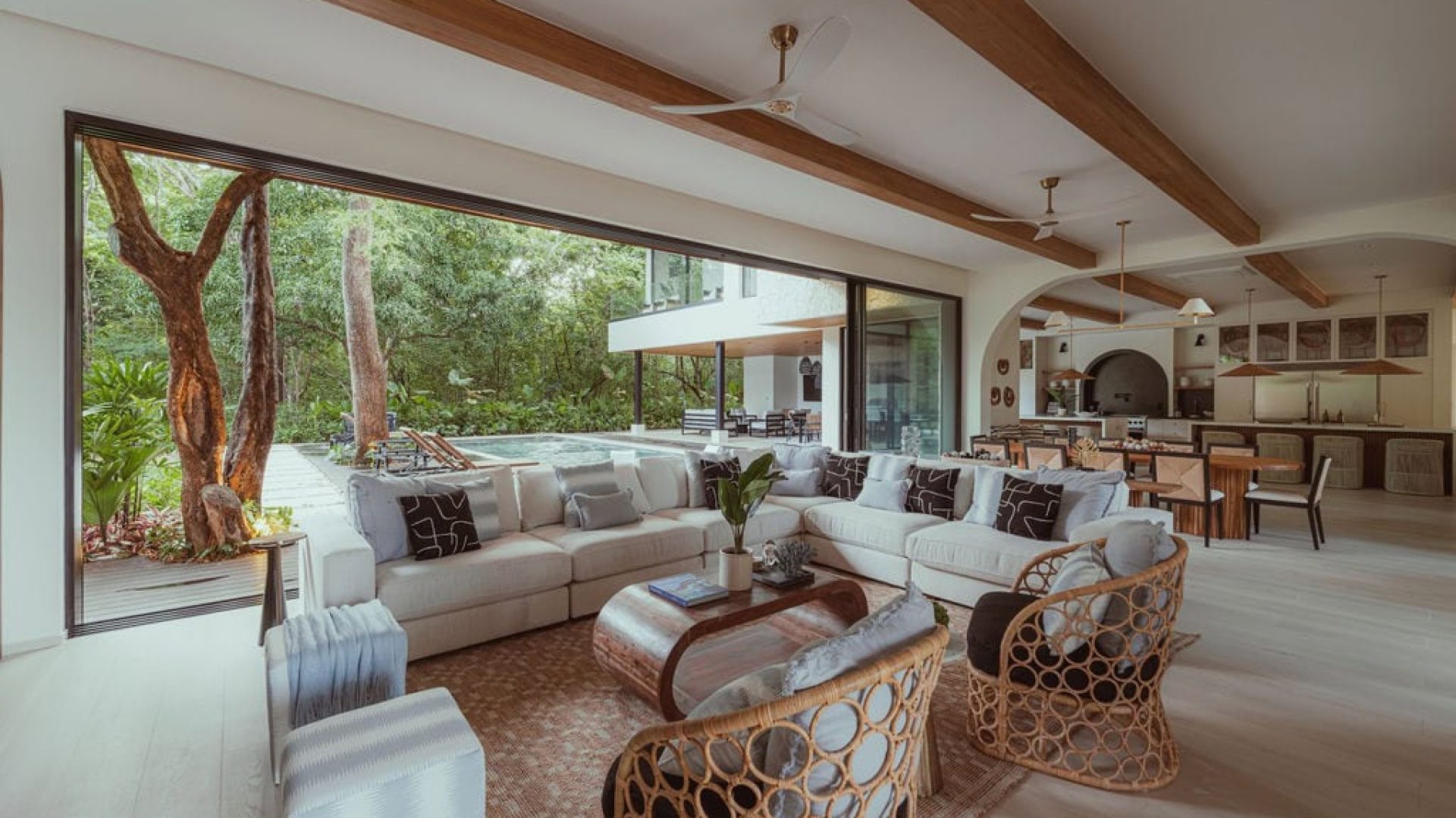 Bright modern living room with large glass sliding doors overlooking lush greenery.
