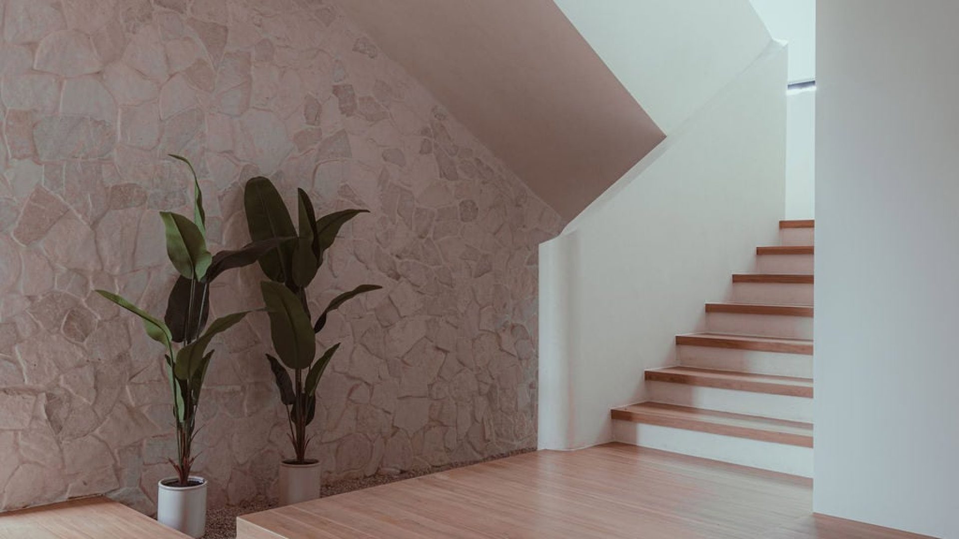 Modern minimalist staircase interior with natural wood flooring and stone wall at Vida Pinilla.