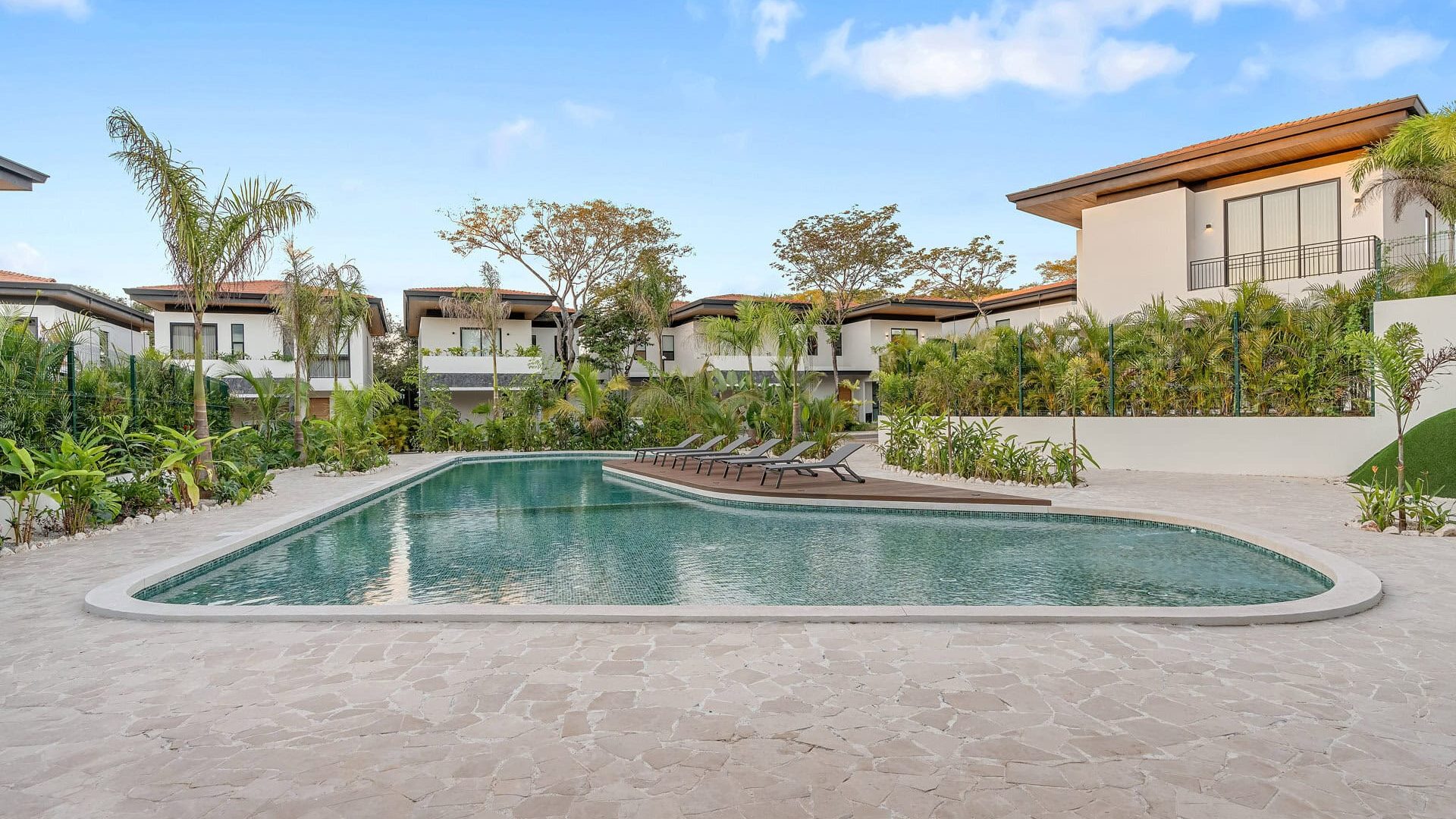Luxurious modern villa with a private swimming pool and lush tropical landscaping.