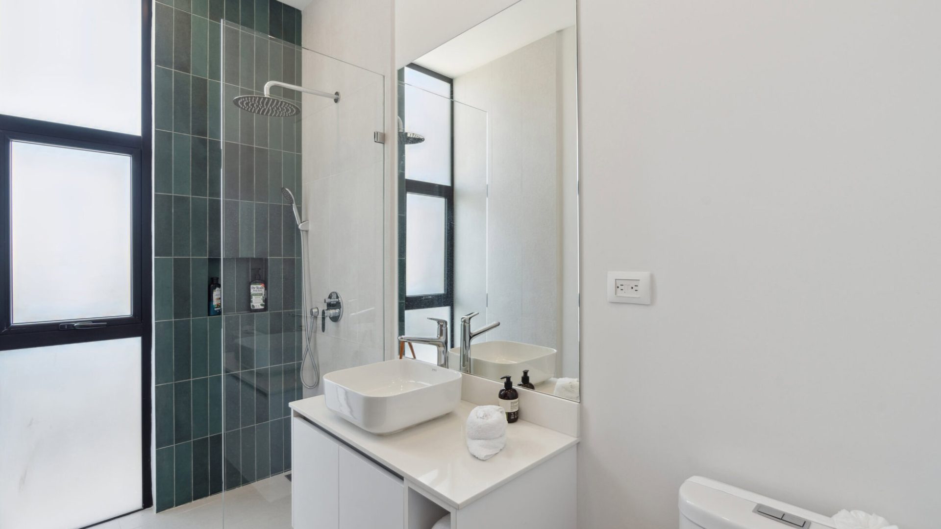 Modern minimalist bathroom with walk-in shower and stylish white vanity.