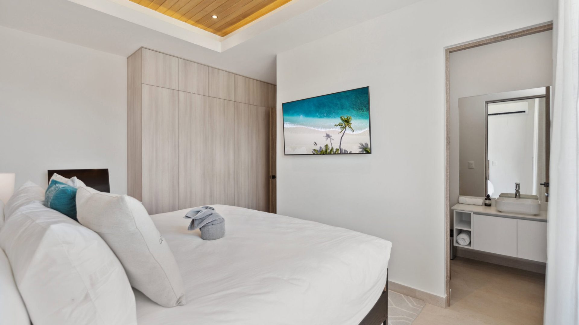 Luxurious modern bedroom with tropical beach decor, minimalist design, and comfortable bedding.