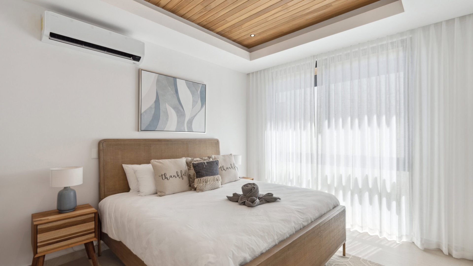 Relaxing bedroom with modern minimalist decor and natural light from large windows.
