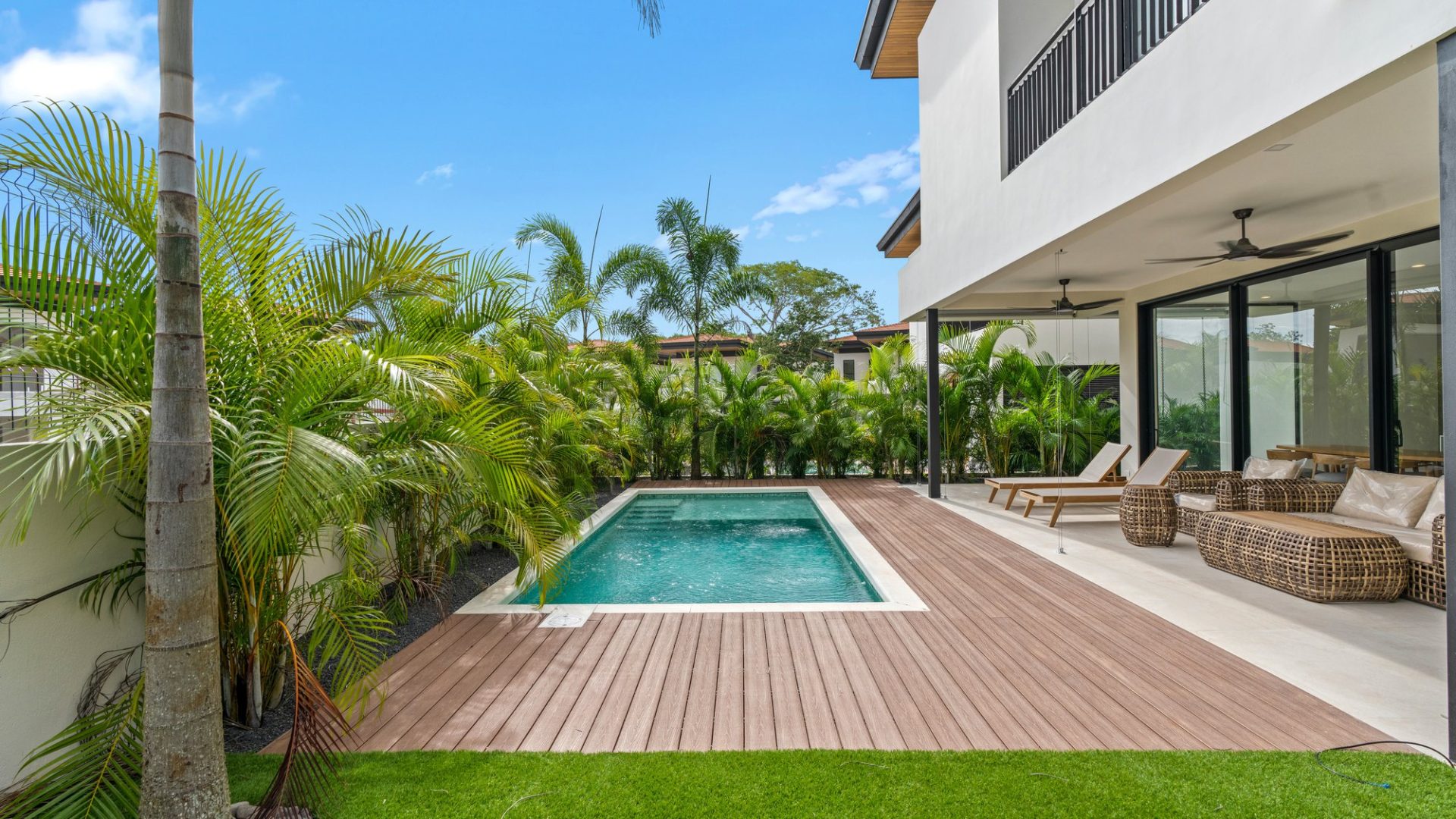 Lush tropical backyard with private pool, outdoor lounge, and modern villa in Vida Pinilla. Perfect for relaxation and outdoor living.