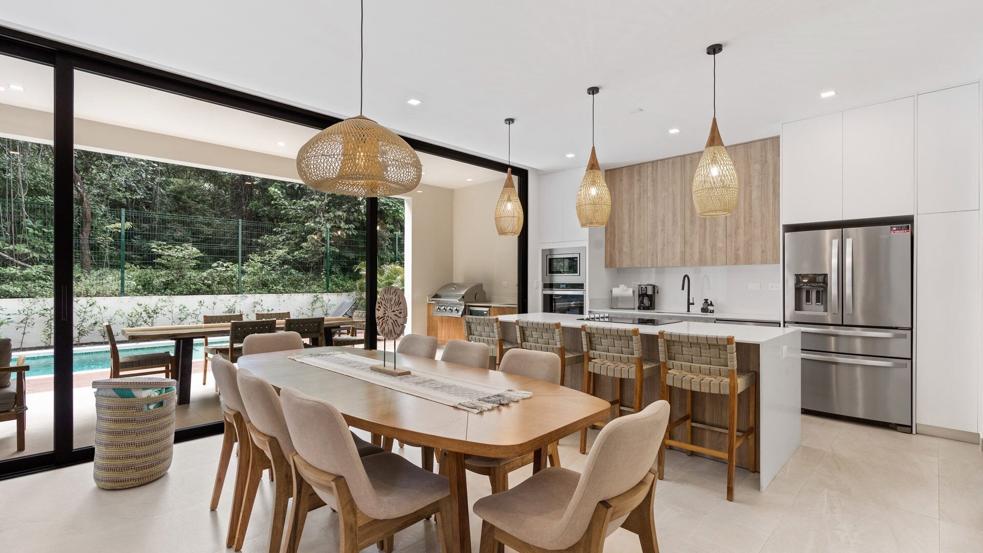 Modern open-concept kitchen and dining area with large sliding glass doors to outdoor space.