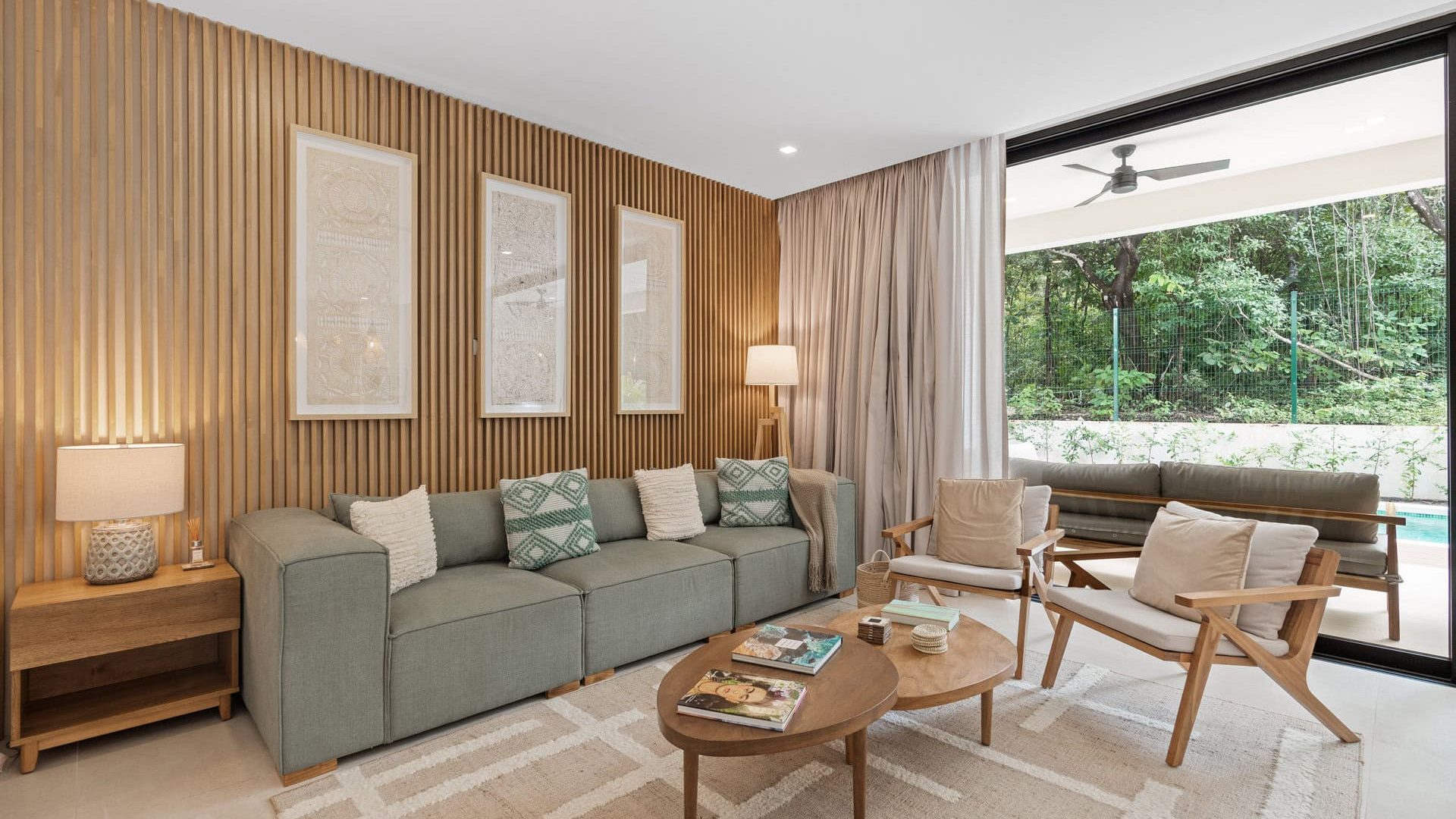 Modern living room with wooden accent wall and outdoor view, stylish furniture, cozy atmosphere, and plenty of natural light.