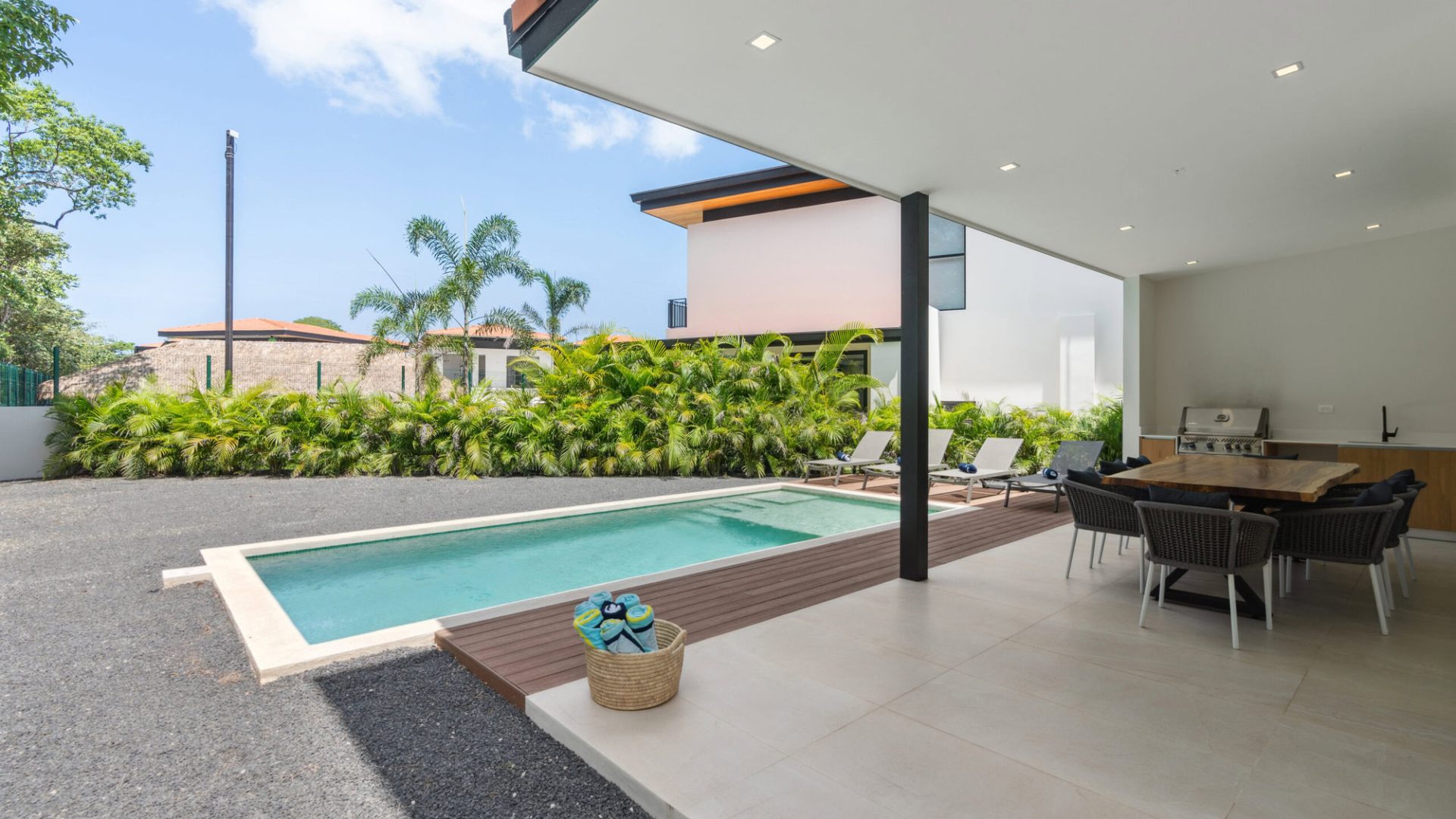 Luxurious modern backyard with swimming pool, outdoor lounge, and tropical landscaping.