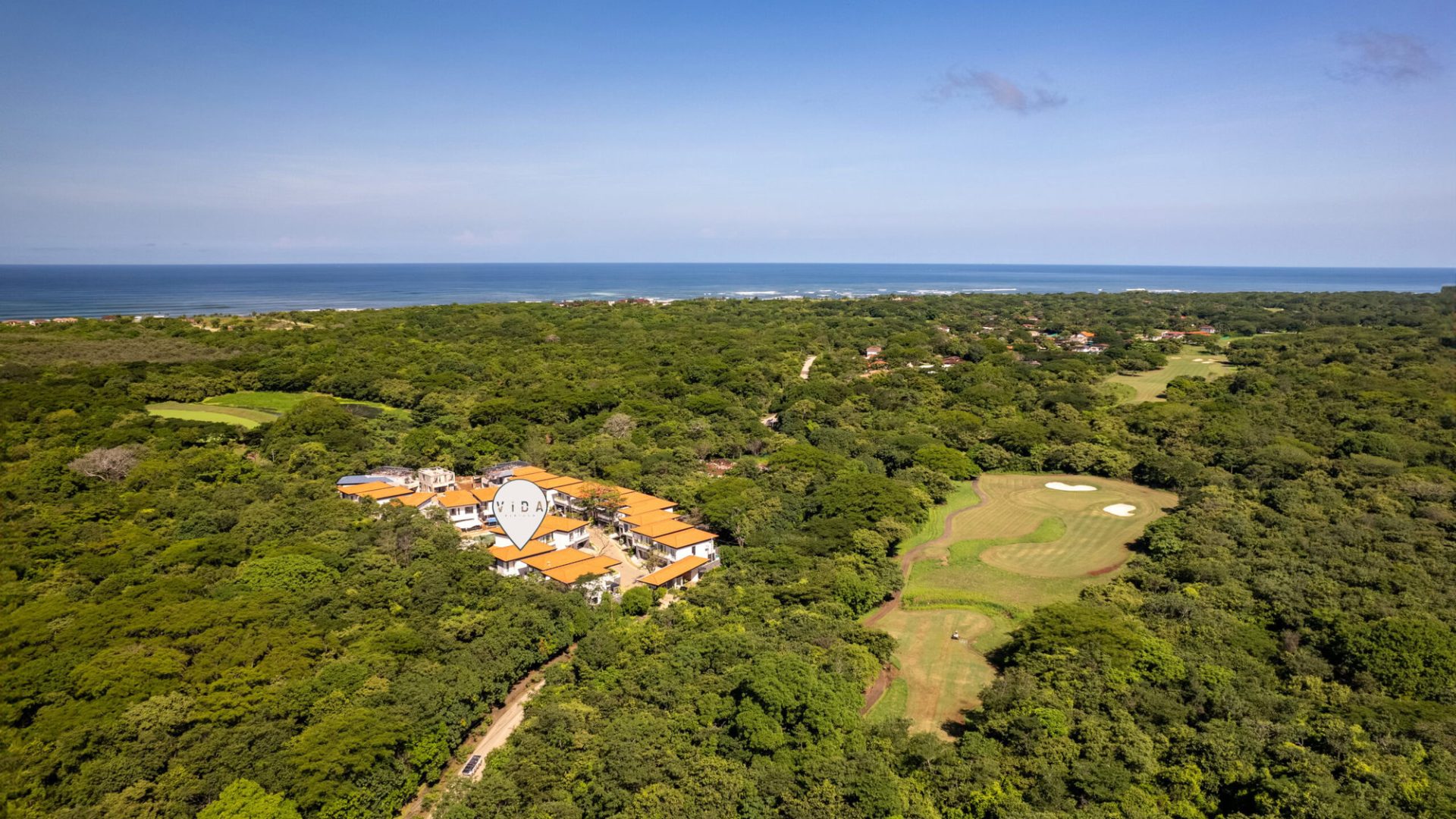 Lush greenery surrounding Vida Pinilla beachfront resort and golf course, scenic ocean view in the background.