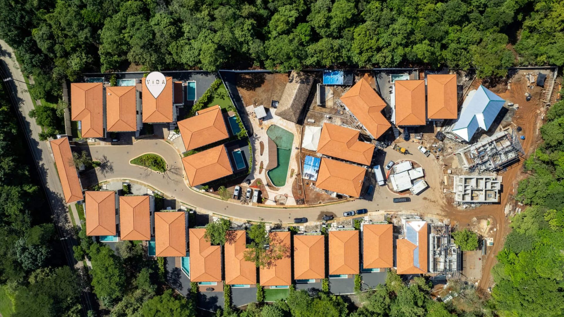 Modern housing community with red-tile roofs and outdoor pool.
