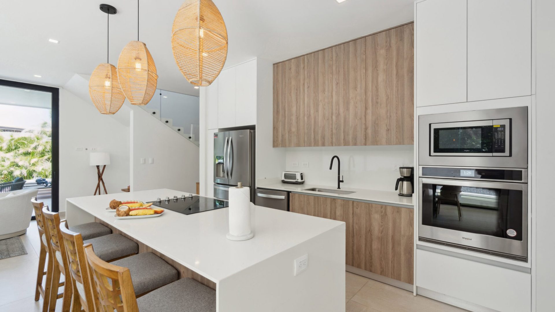 Modern kitchen with white cabinets, wooden accents, and stainless steel appliances at Vida Pinilla.