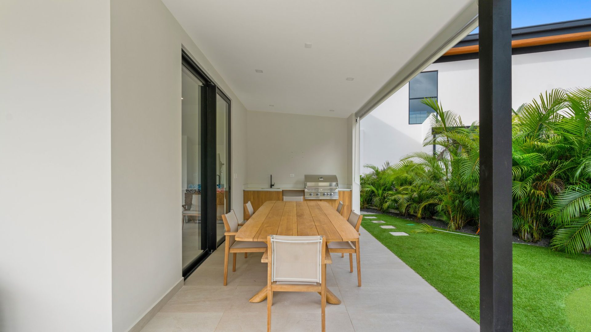 Modern outdoor dining area with a wooden table and garden view at Vida Pinilla.