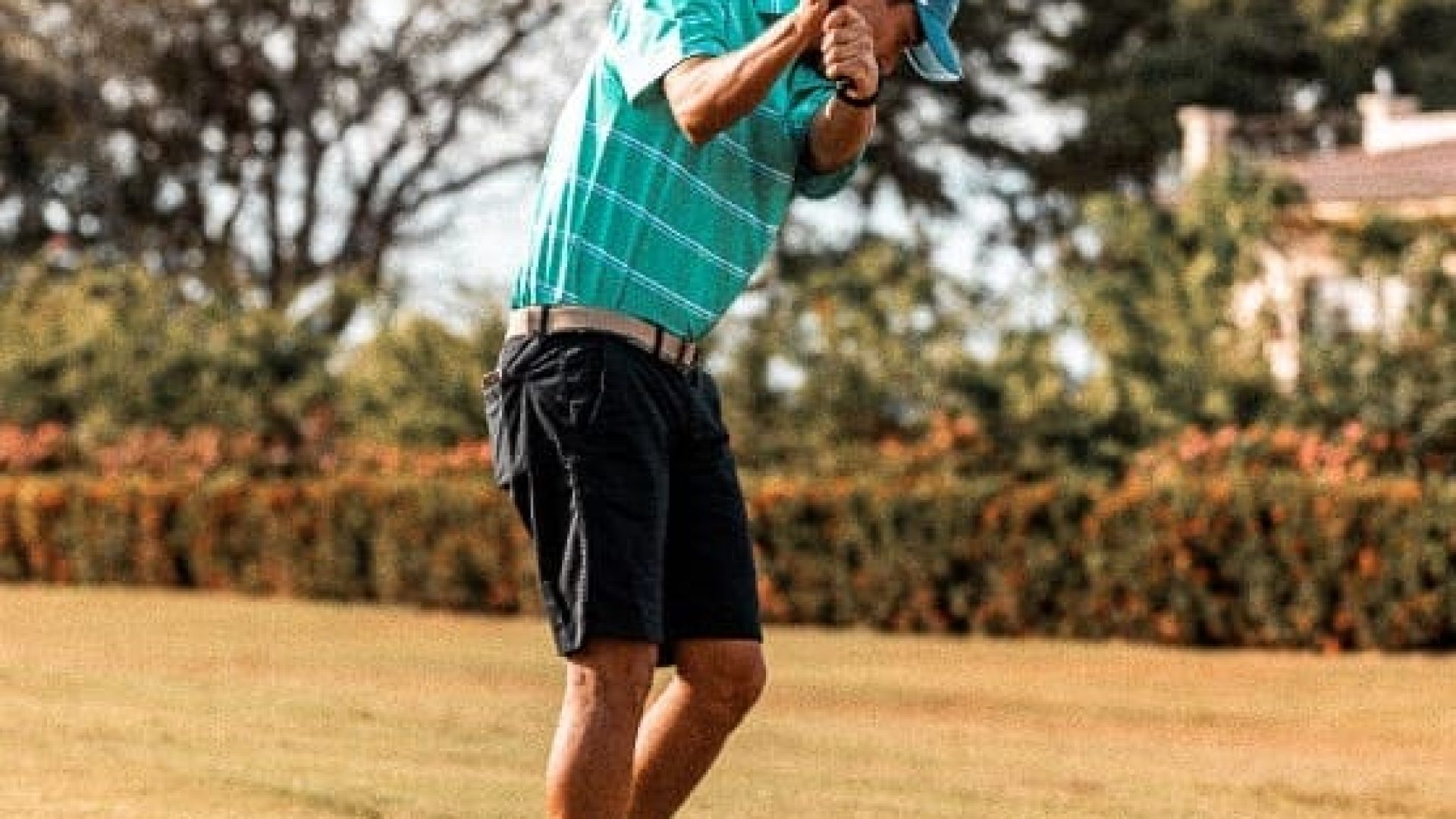 Golf player swinging club on lush course at Vida Pinilla. Perfect swing during a sunny day in scenic outdoor setting.