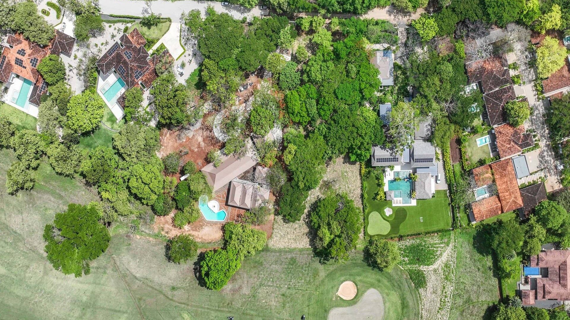 Lush green backyard with swimming pools and outdoor amenities in a residential neighborhood.