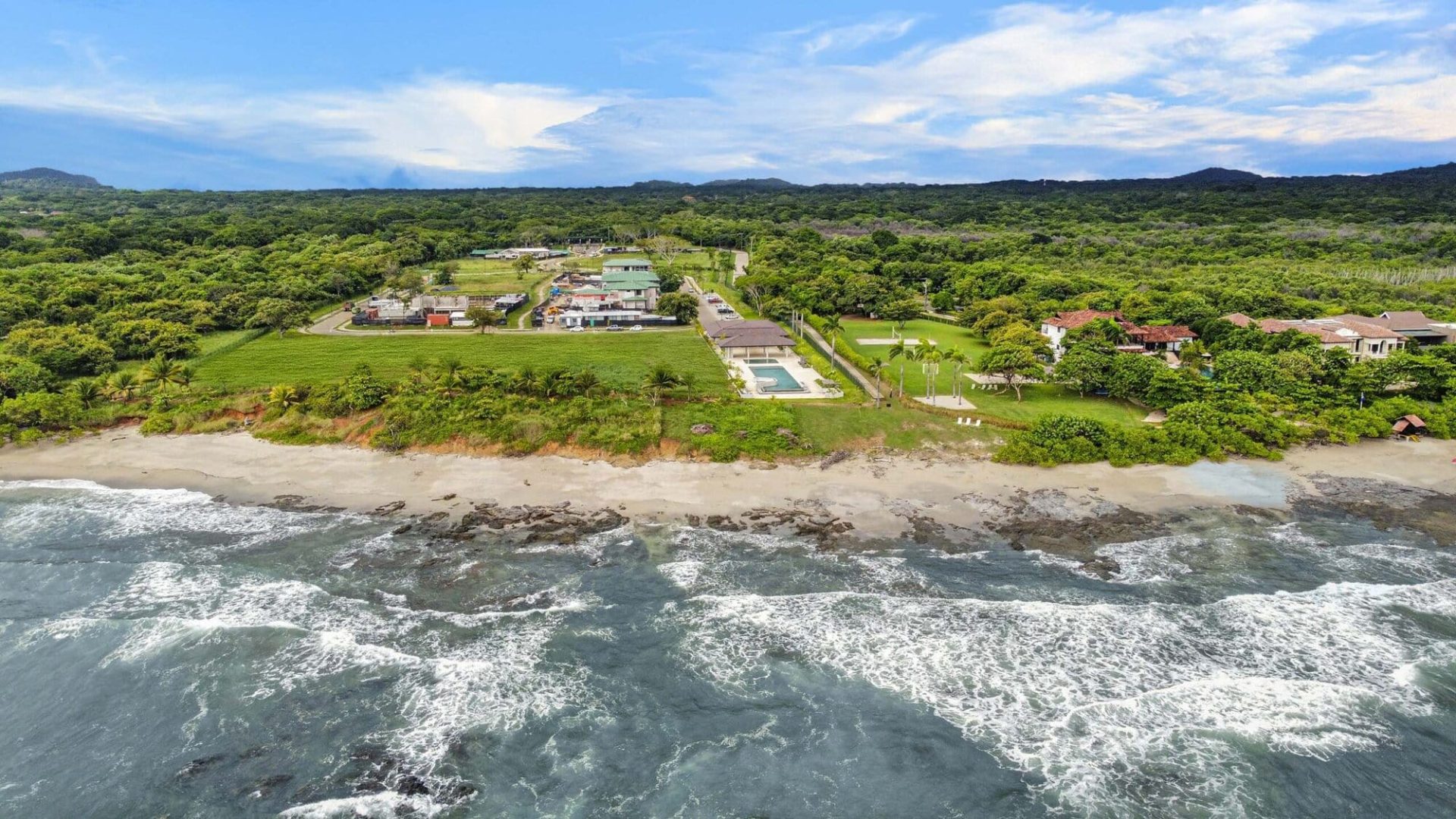 Stunning aerial view of Vida Pinilla beachfront property with lush greenery and ocean waves.