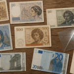 billet de banque france sur table avec loupe et carnet