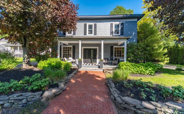 A welcoming Bemus Point NY home that looks cozy and inviting, with plenty of plants and a clear path to the door.