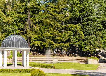 A serene white gazebo nestled in a picturesque park, offering a tranquil spot for relaxation and gatherings.