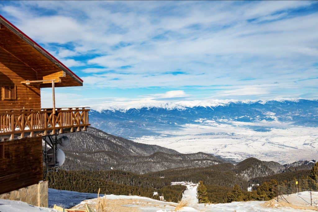 Mountain view from a wooden chalet in Bulgaria with snowy peaks – mountain and spa towns in Bulgaria
