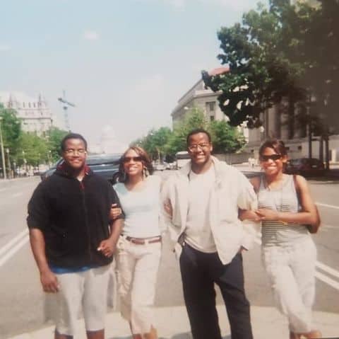 A group of four diverse people walking on a city street, enjoying urban art and cityscape, representing community and culture at Visual Arts Passage.