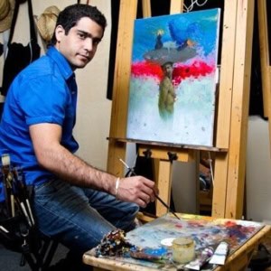 A young male artist painting vibrant abstract art on canvas at Visual Arts Passage art studio.