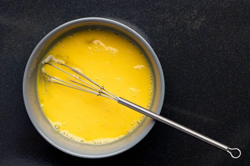 Closeup of beaten eggs in a bowl with a whisk 2023 01 10 02 54 27 utc large
