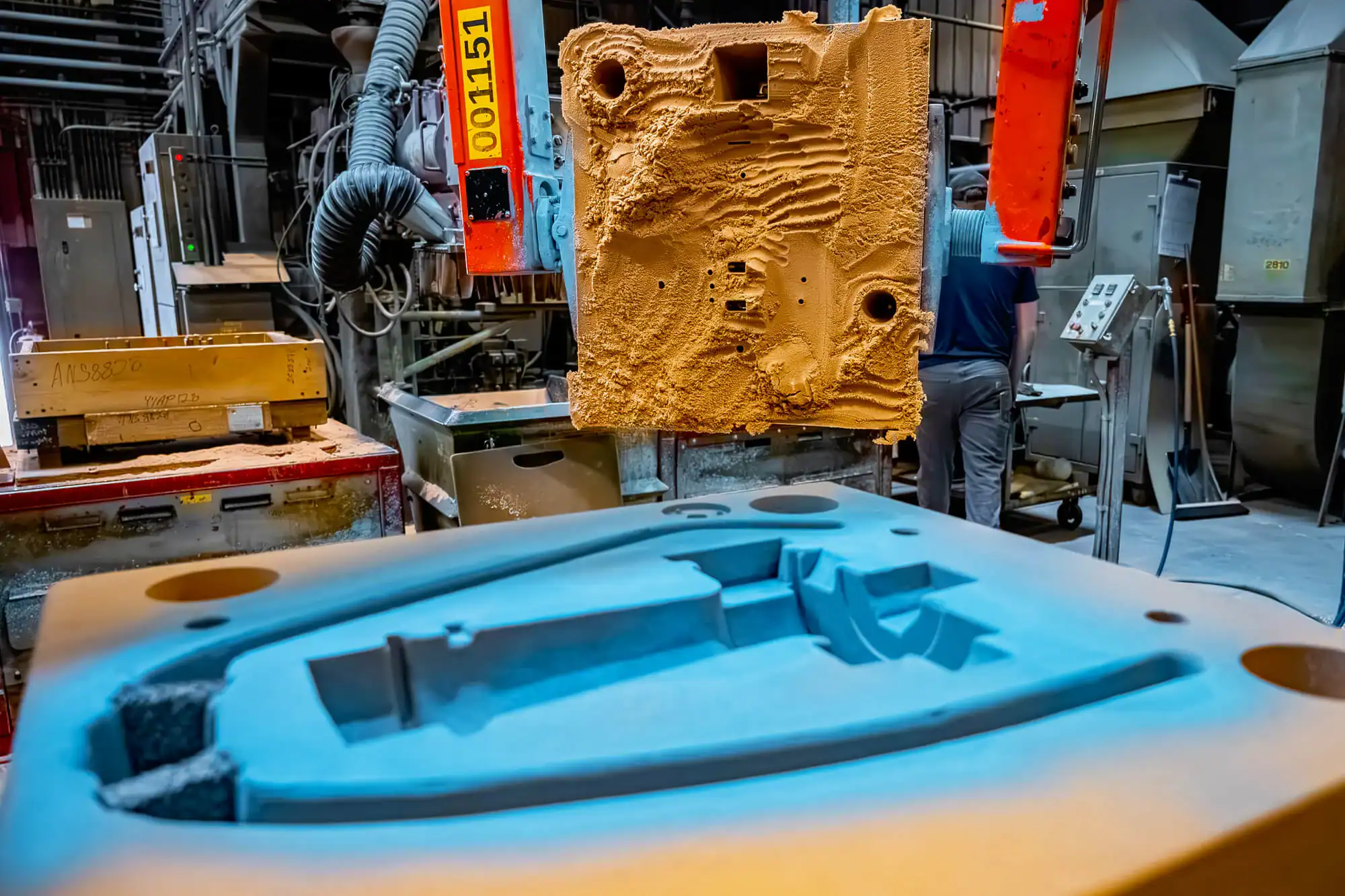 Close-up of air set mold with air set machinery in the background, onsite at Wisconsin Aluminum Foundry.