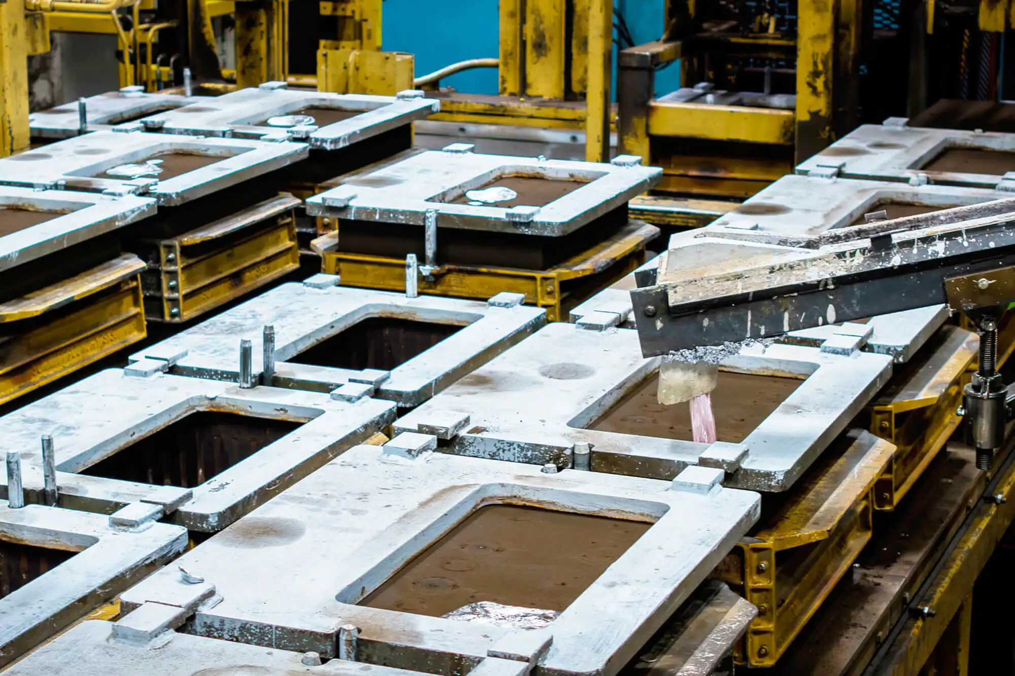 Symmetrical green casting molds arranged and ready for aluminum pouring.